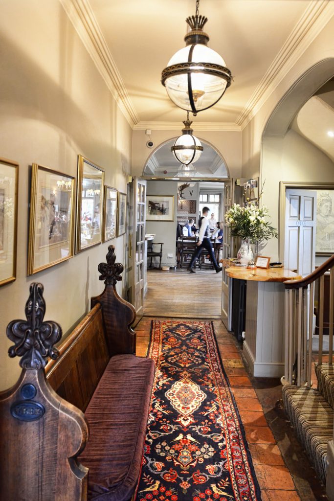 Elegant hallway with ornate rug and antique bench.
