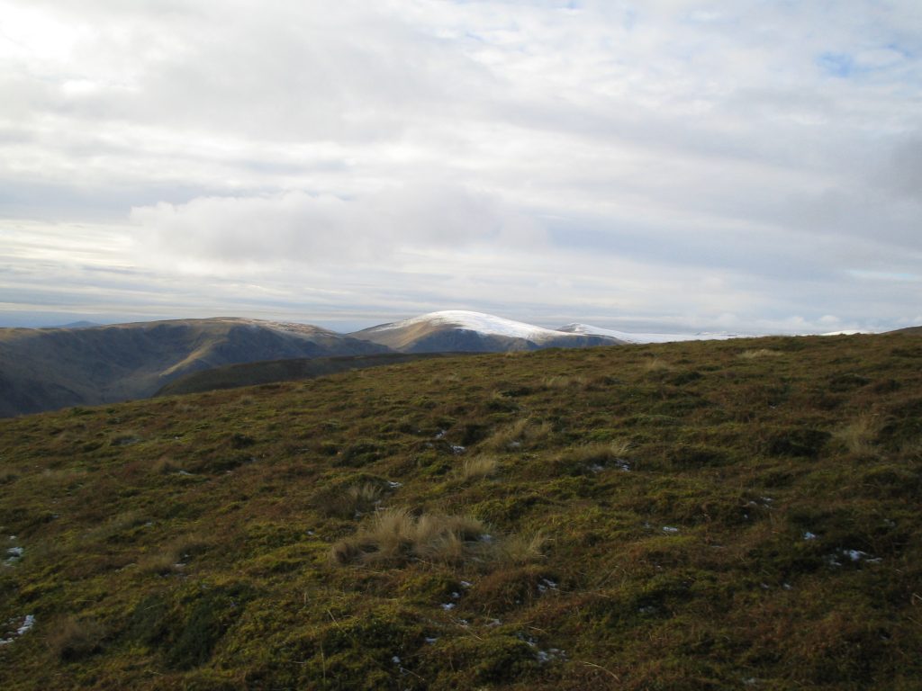 Snow-covered mountains under cloudy sky, Scotland view.