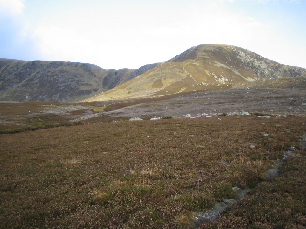 Scenic Scottish Highlands landscape with grassy hills.