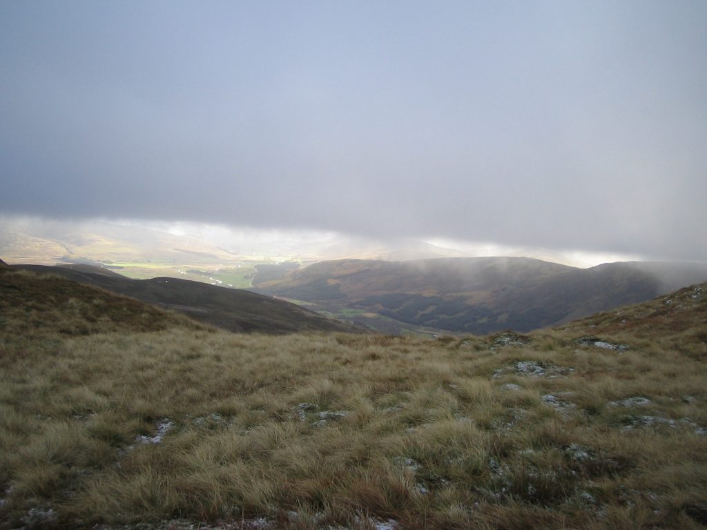 Misty mountain landscape with grassy foreground.