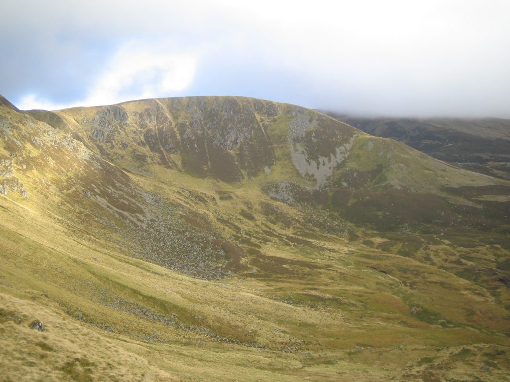 Mist-shrouded Scottish mountain landscape under cloudy sky.